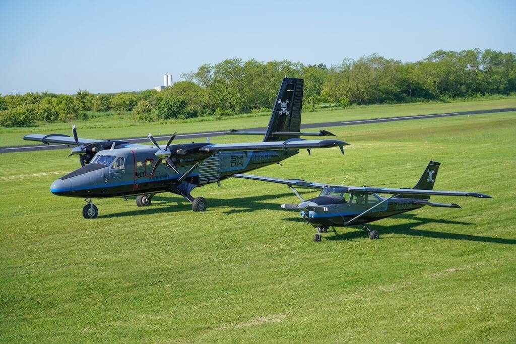 Two skydiving airplanes parked side by side.