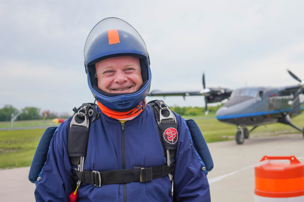 Skydiver smiling as he is about to board an aircraft.