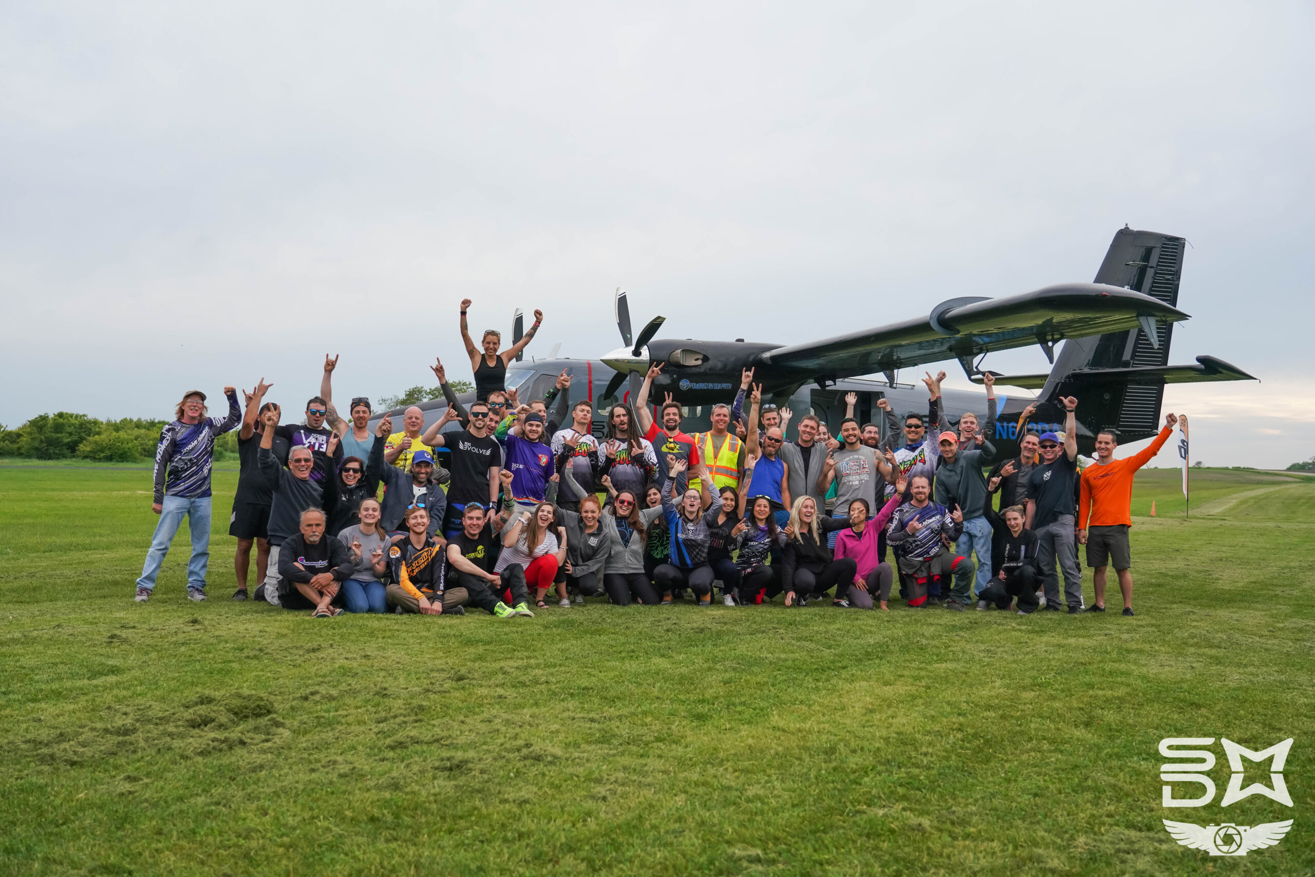 The Skydive Midwest staff standing in front of a twin otter airplane.